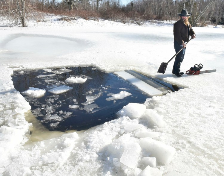 Amish farmer Isaac Hostetler separates with a shovel a large block of ice he cut from a pond at his farm in Palmyra on Wednesday. The ice will be used for an ice bar during Somerset SnowFest this weekend. 