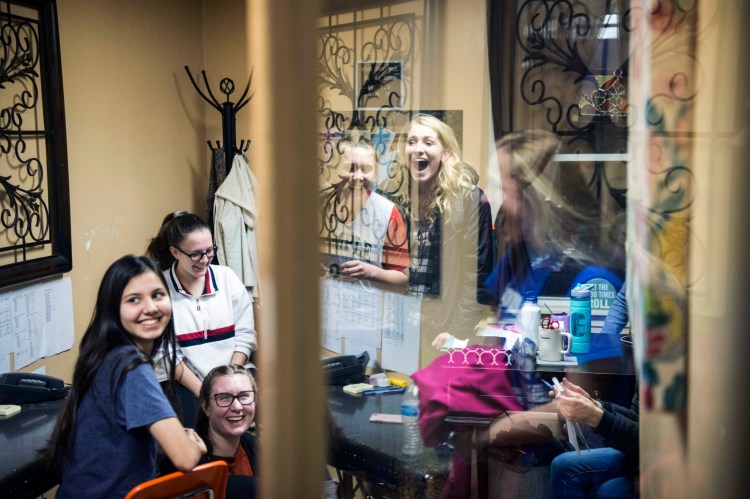 The Temple Academy girls basketball team gathers in the coach's office before practice at Temple Academy in Waterville on Friday. Students from nine countries are on the team. Several have never played basketball, but the team is headed for the state tournament with a 14-4 record.