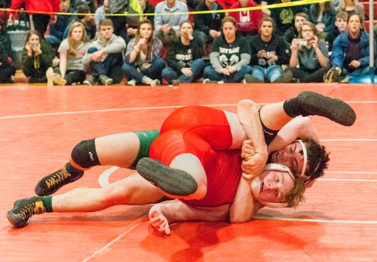Cony's Aaron Lettre, bottom, wrestles with Oxford Hills' Cole Dunham during the 182-pound championship bout at the Class A state meet last season at Cony High School.