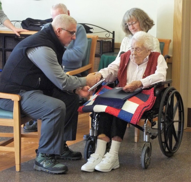 The Rev. John Bilowith, left, from Beacon Hospice, holds Jean Smith's hand while offering a small prayer on her behalf 
and for all the others who have served our country, while Katie Farrin listens. 
