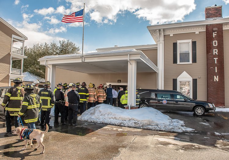 Firefighters in turnout gear arrive in Lewiston to escort the body of  Oxford Fire Chief Gary Sacco into the Fortin funeral home. 