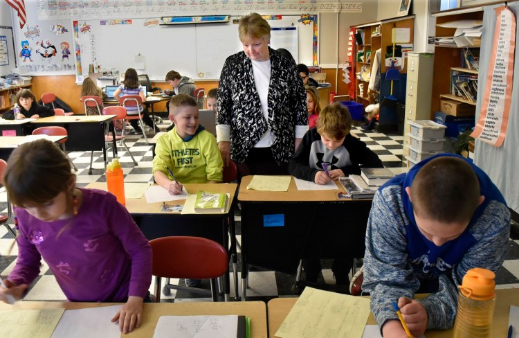 Quimby Middle School teacher Cathy Foran works with her fourth-grade students Wednesday at the school in Bingham. District voters have decided to close the school at the end of the school year. 