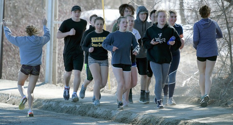 Members of the Maranacook track and field teams head out for a run during a preseason practice in Readfield.