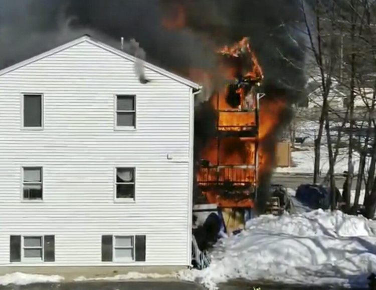 Flames tear through the apartment building at 10 Bell St. in Berwick on March 1 in this image from a neighbor's video. Fire officials said Friday that the fire was started by discarded smoking materials.
