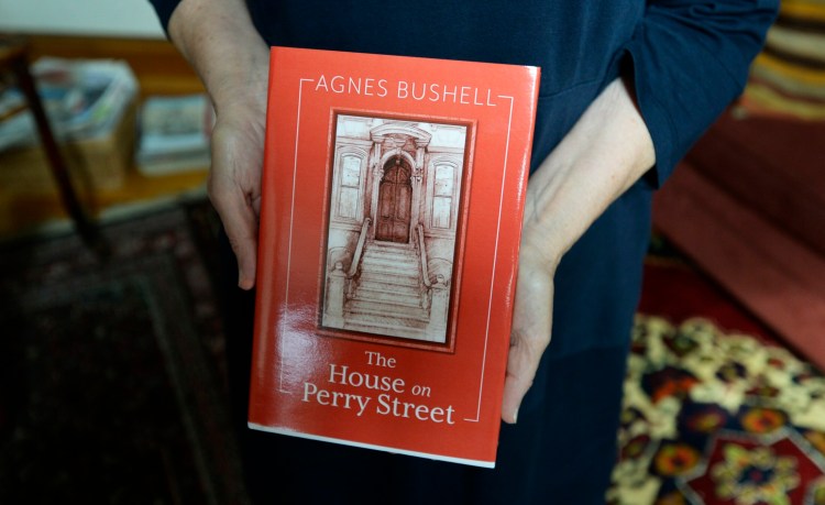 Writer Agnes Bushell holds a copy of her book "The House on Perry Street" in September 2018.