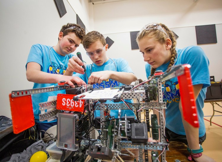 Maine School of Science and Mathematics teammates Wesley Chalmers, left, a sophomore, Chandler Pike, a freshman, and Madison McCarthy, a sophomore, make repairs to their robot between matches in the Maine VEX State Robotics Championship on Feb. 23 in South Portland. Their school has been ranked second in the nation by U.S. News and World Report.