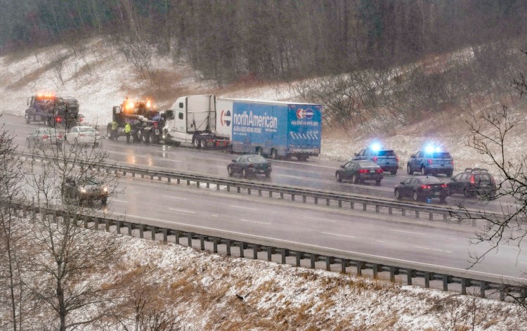 Workers connect a tow truck to a tractor-trailer that was in a crash involving multiple vehicles at mile marker 34 in the northbound lane of the Maine Turnpike in Saco on Monday morning.
