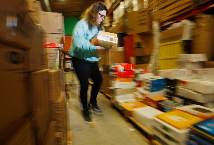 Volunteer Lizzy Wise upacks boxes of donations at Ruth's Resusable Resources. 