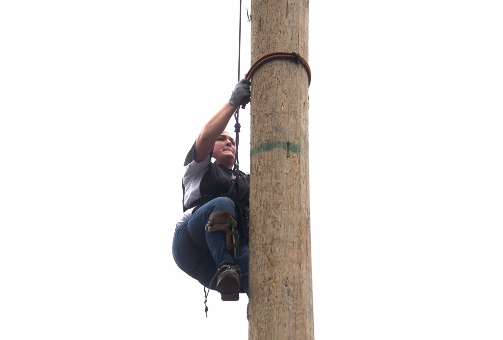 The University of Maine's Abigail Weckesser lowers herself from the top of a 40-foot-high wooden pole Saturday during the pole climbing competition at the annual Woodsmen's Mud Meet at Colby College in Waterville.