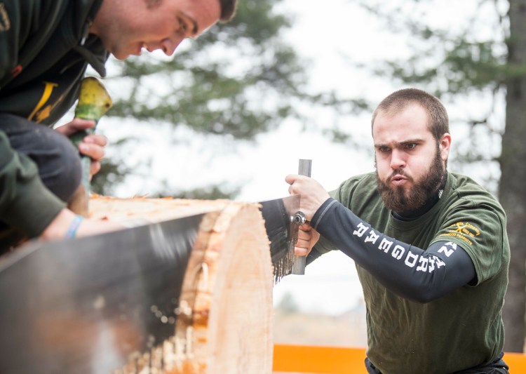 Unity College's Brodie Holmes competes Saturday in the single-person crosscut competition at the annual Woodsmen's Mud Meet at Colby College in Waterville.