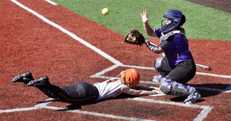 Winslow's Katie Bailey slides safe into home as Waterville catcher McKayla Nelson reaches for ball on Wednesday.