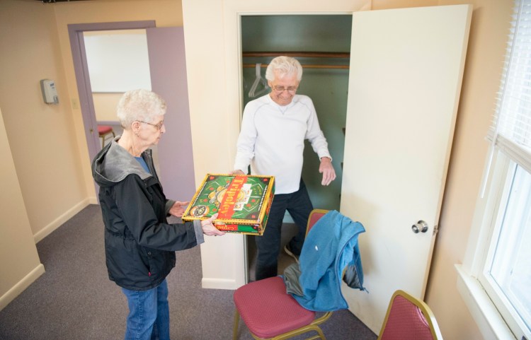 Pauline Matthieu hands games to Chuck Pare to be put away at the Oakland Senior Center. The center at 47 Heath St. in Oakland will host an open house Tuesday from 10 a.m. to noon. 