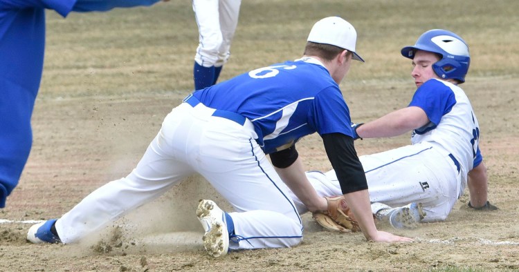 Erskine's Joe Clark tries to tag Lawrence baserunner Mike Roy during a close play at third base Thursday in Fairfield. Roy was called safe on the play.