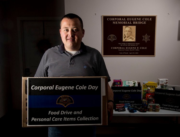 Richard LaBelle, town manager of Norridgewock, stands on Friday with donations made in memory of Cpl. Eugene Cole at the Norridgewock Town Office. LaBelle said collecting food and personal items and distributing them to those in need in the community is a positive way for all to remember Cole.