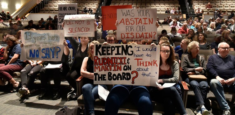SAD 49 students hold signs up in the front row toward school board members and Superintendent Reza Namin during a well attended meeting with students, faculty and parents in Fairfield on Thursday.