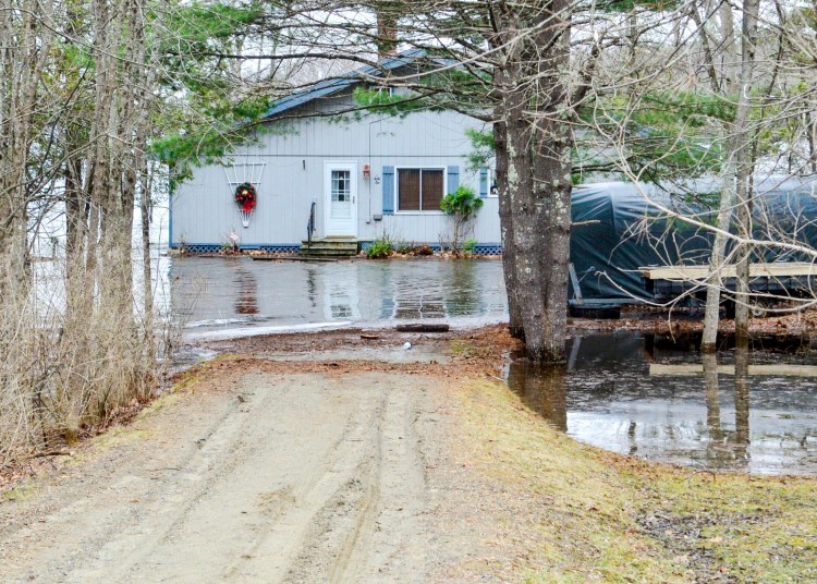 High water from Androscoggin Lake surrounds one of two homes on Route 133 near the state boat launch on Friday in Wayne.