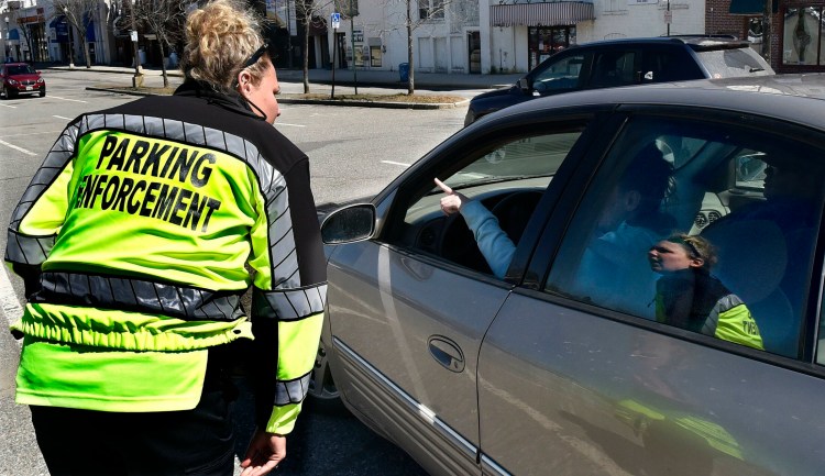 Waterville's Parking Enforcement Officer Anna Grant assists a motorist with directions in the Concourse in Waterville on Monday.