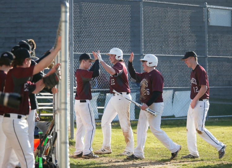 Nolan Kent celebrates with teammates Bryce Afthim  and Caleb McCartney  after they scored in the sixth inning of the Eagles' 9-4 win over Falmouth on Tuesday in Falmouth.