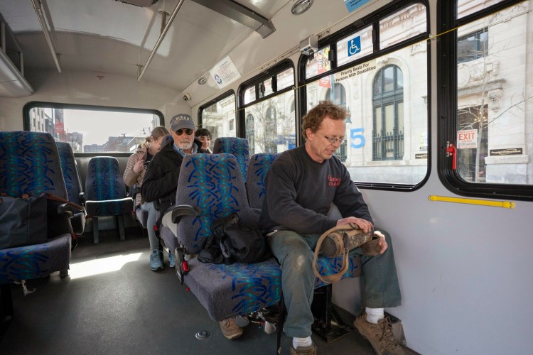 Mike Spaulding of Brunswick pours coffee from his thermos while riding the Breez commuter bus along Congress Street in Portland on Monday. The Breez has been more successful than anticipated and Portland Metro is proposing to make the bus route to the northern suburbs permanent. 
