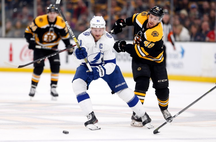 Tampa Bay's Steven Stamkos and Boston's Matt Grzelcyk battle for the puck during the first period  of the Lightning's 6-3 win Saturday in Boston.