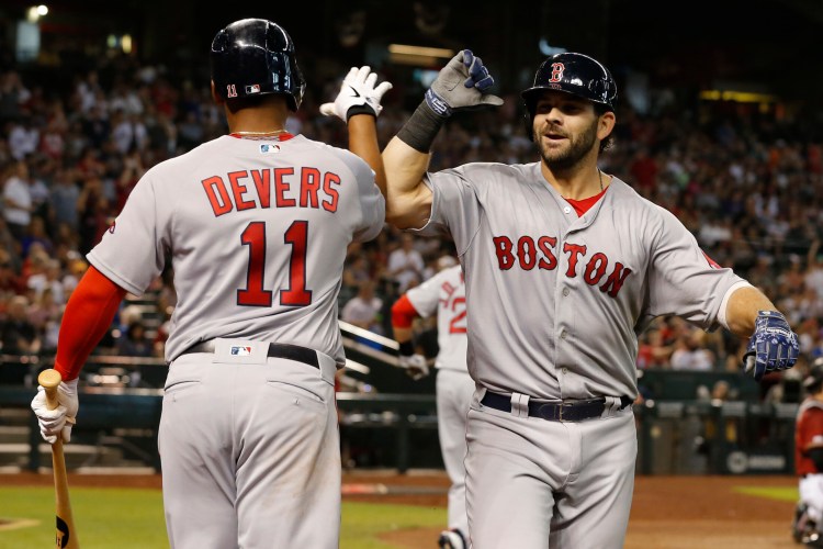 Mitch Moreland, right, celebrates with Rafael Devers, after Moreland hit a solo home run in the seventh inning to lift the Red Sox to a 1-0 win on Sunday in Phoenix.