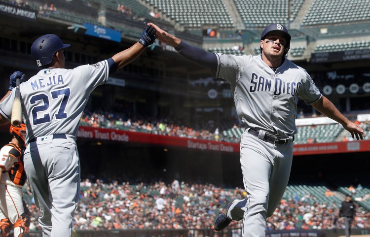 San Diego's Hunter Renfroe, right, is congratulated by Francisco Mejia after scoring a run against the San Francisco Giants in the ninth inning Wednesday.