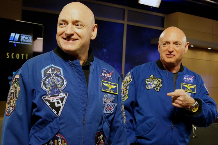 In this March 4, 2016 file photo, NASA astronaut Scott Kelly, left, and his identical twin, Mark, stand together before a news conference in Houston. 