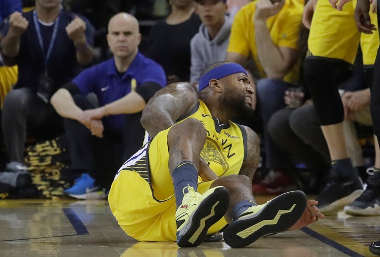 Golden State center DeMarcus Cousins reacts after falling to the floor during the first half of Monday's Game 2 loss to the Clippers. Cousing suffered a torn quadriceps muscle and is out indefinitely. (Associated Press/Jeff Chiu)