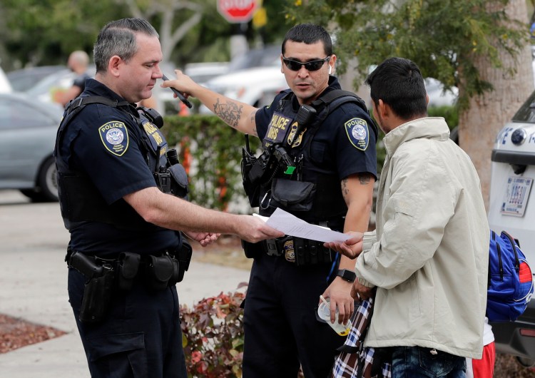 Homeland Security police direct people where to go outside a U.S. Immigration and Customs Enforcement facility this year in Miramar, Fla. Maine lawmakers are considering two bills with different policies on how local police officers would interact with federal immigration officers.