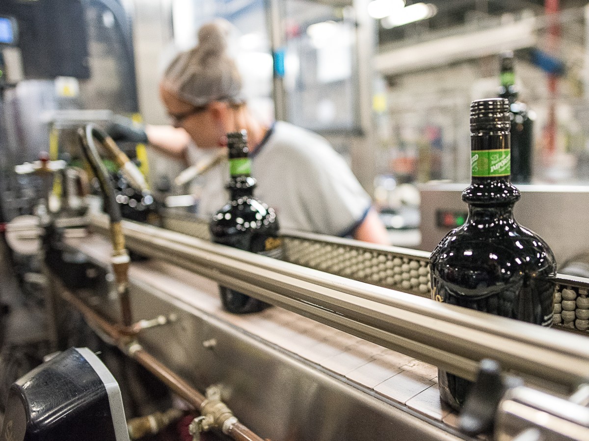 Carol Parlin checks the labels on bottles of liquor at the Sazerac bottling plant in Lewiston on Saturday morning, when a $1 million expansion to the bottling plant was announced. (Andree Kehn/Sun Journal)