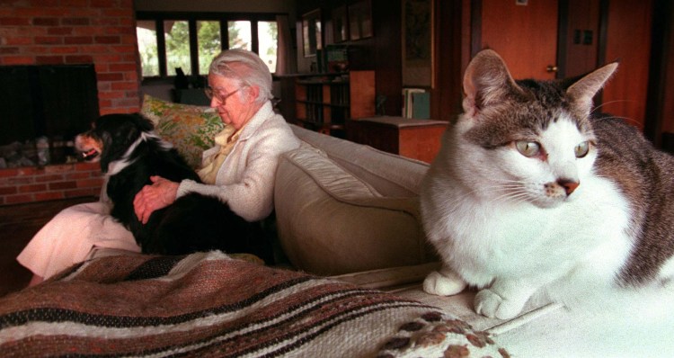Geraldene Wright of Pemaquid holds her dog while one of her 14 cats averts its eyes in 1997. 
