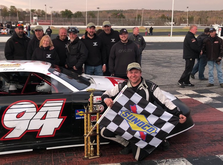 Garrett Hall holds the checkered flag after winning the PASS 150 on Sunday at Oxford Plains Speedway.