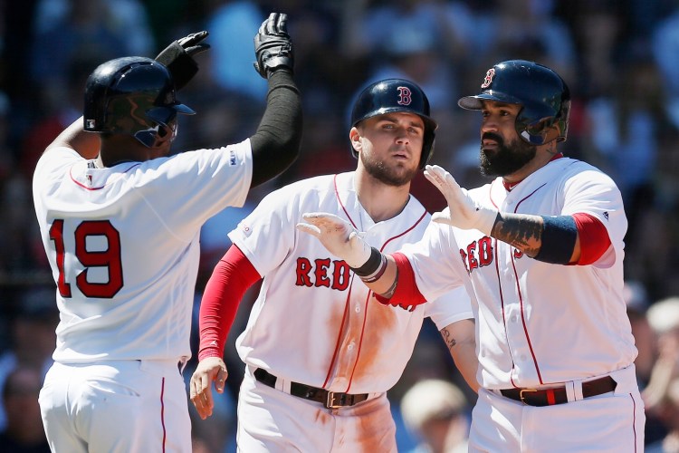 Boston’s Sandy Leon, right, celebrates his three-run home run with Michael Chavis, center, and Jackie Bradley Jr. on Saturday in Boston. The Red Sox beat Seattle, 9-5.