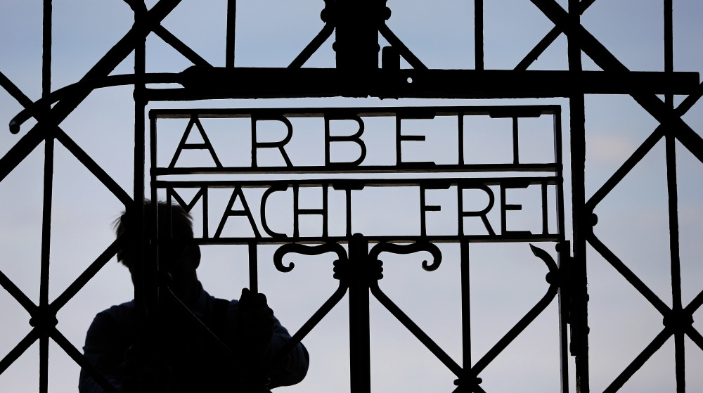 A  blacksmith prepares a replica of the Dachau camp gate with the German slogan for "Work sets you free." Dachau, the first Nazi concentration camp, opened in 1933