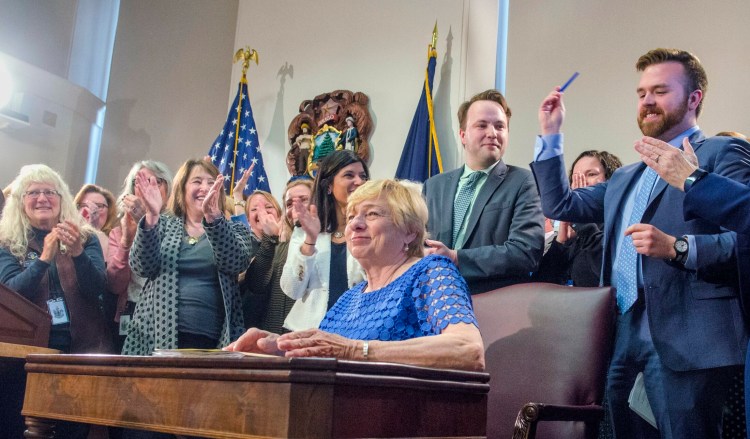 Dozens of House and Senate co-sponsors cheer after Gov. Janet Mills signed into law a bill banning the practice of conversion therapy in Maine. 
