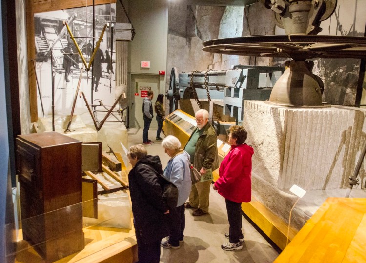 People look at display about ice harvesting and granite quarrying on May 1 at the Maine State Museum in Augusta.