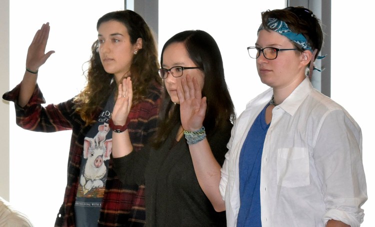 Colby College students, from left, Anna Braverman, Lutie Brown and Colleen George are sworn in to testify before the  Waterville Voter Registration Appeals board during a hearing in Waterville regarding voter eligibility on May 1, 2019. Their votes were challenged by residents who opposed the plastic bag ban in Waterville. Brown has continued on since then to be elected in November 2019 the Ward 3 representative on the city Charter Commission and active in the local Democratic Party.