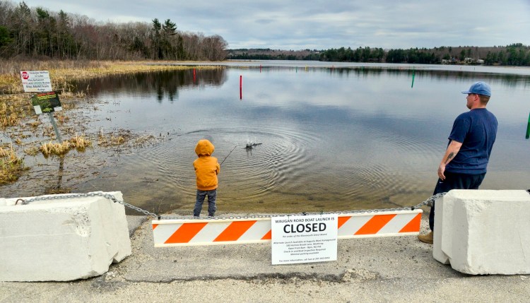 Noah Allen, 4, of Wales, left, casts into Annabessacook Lake as his father, Zachary Allen, watches Wednesday at the closed boat launch on Waugn Road in Monmouth. 