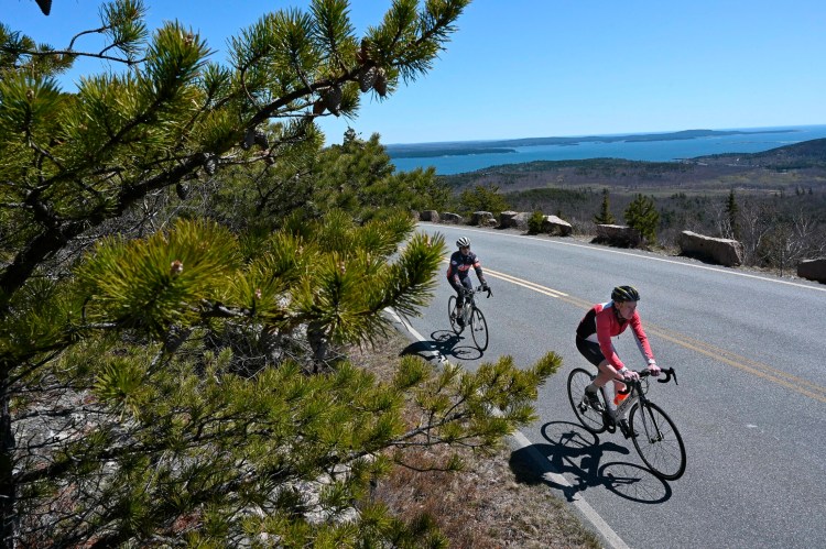 Biking enthusiasts Dean Read, left, and Bob Carroll bike up Cadillac Mountain in early May. It took them just 23 minutes to reach the summit. 