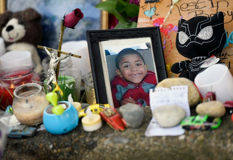 A photograph of Jayce Holt is placed at a makeshift memorial Thursday near where he was struck and killed by a school bus on the previous afternoon. 
