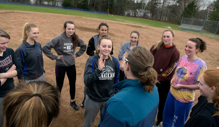 Erskine softball players gather in a circle and praise their teammate Parker King, center, following practice at the school Thursday in South China.