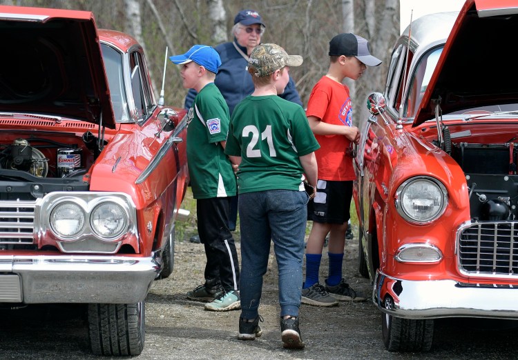Baseball players inspect during the cruise in of cars Sunday at the CARA fields. A fundraiser was held to replace a concession stand at the complex destroyed by fire.