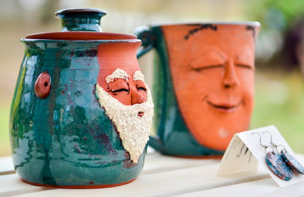 Face mugs made by guest artist Martha Hoddinott are offered for sale Saturday during a Maine Pottery Tour event at Fine Mess Pottery in Augusta. 