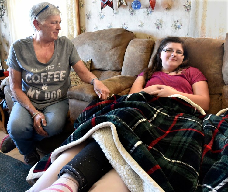 Cierrah French, 13, rests and recuperates at her grandparents’ home in Skowhegan after surgery two weeks ago for a rare form of cancer in her right knee. Her grandmother Alecia Blodgett comforts her on Monday.