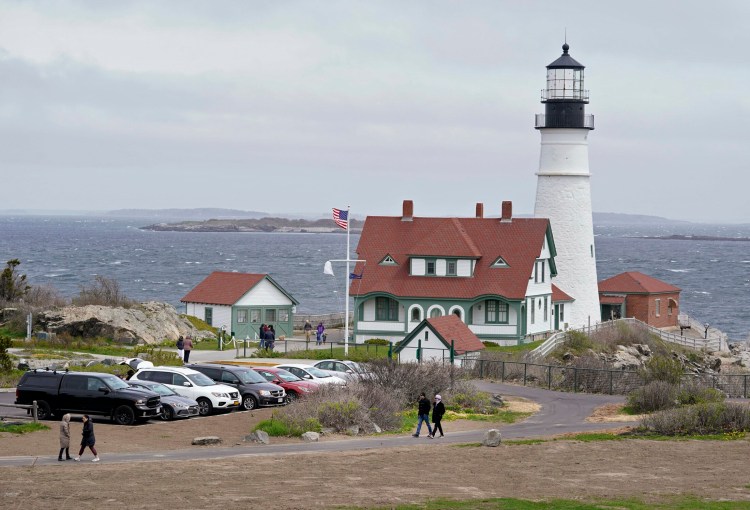 People visit Portland Head Light at Fort Williams Park in Cape Elizabeth on Monday. The Town Council decided Monday night to start charging people from out of town to park in the lots closest to the lighthouse and scenic paths, to fund the park's operations.