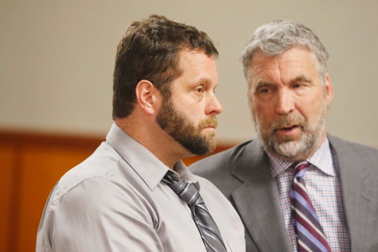Shawn Purvis, left, stands in court with his attorney, Thomas Hallett, during his arraignment on the charge of workplace manslaughter in the death of a worker who fell from the roof of a house in December 2018. 