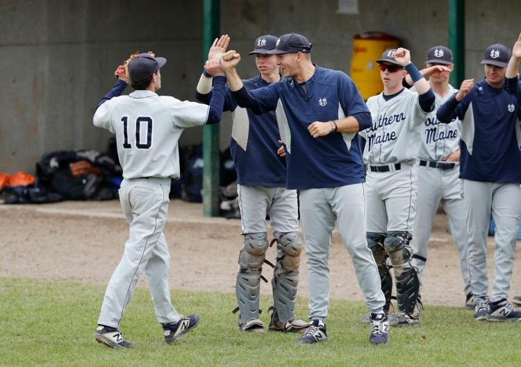Ben Lambert is congratulated on his way to the dugout during the University of Southern Maine baseball team's 16-4 win over NEC in the NCAA Division III baseball tournament on Sunday in Gorham. The Huskies forced the winner-take-all game with the win. 