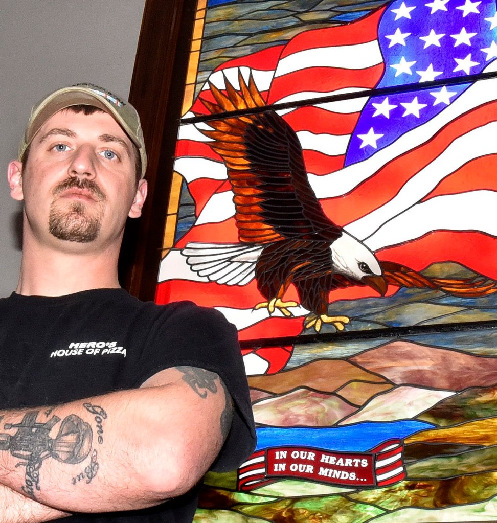 Veteran Derek DeFelice, standing on Wednesday before a patriotic-themed stained glass window in the Skowhegan Town Office, is the grand marshal for the Skowhegan Memorial Day parade this Monday.