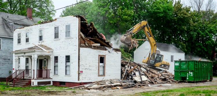 An excavator demolishes 18 Green St. in Augusta on Tuesday. The old house was across the street from Green Street United Methodist Church.