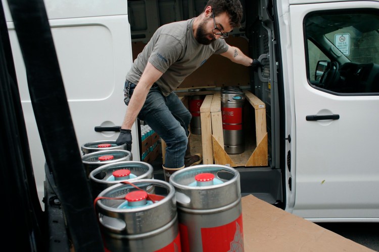 Britton Beal, a drayman at Goodfire Brewing Co., loads a truck before making deliveries in Portland on Thursday. Legislators are considering a new law that would let Maine brewers produce much more beer before having to sign agreements with distribution companies. The change would give craft brewers more flexibility to grow and distribute on their own terms, supporters say.
